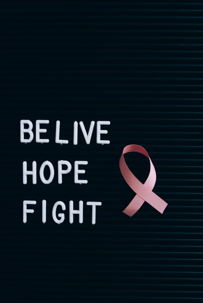 Close-up of letterboard with pink ribbon promoting breast cancer awareness and hope.
