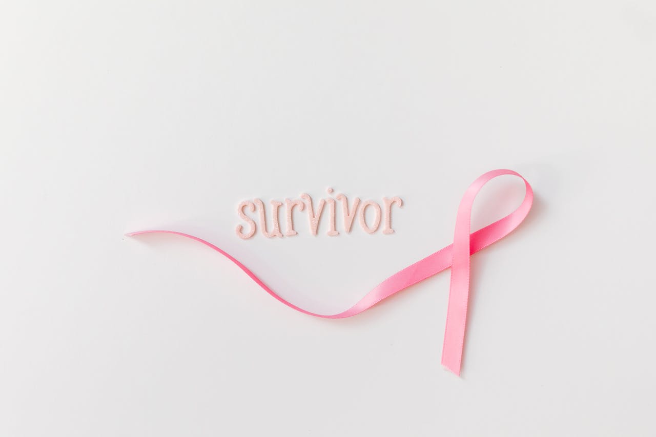 Pink ribbon next to 'survivor' text symbolizing breast cancer awareness and hope.